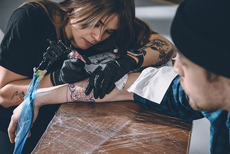tattoo artist giving a tattoo
